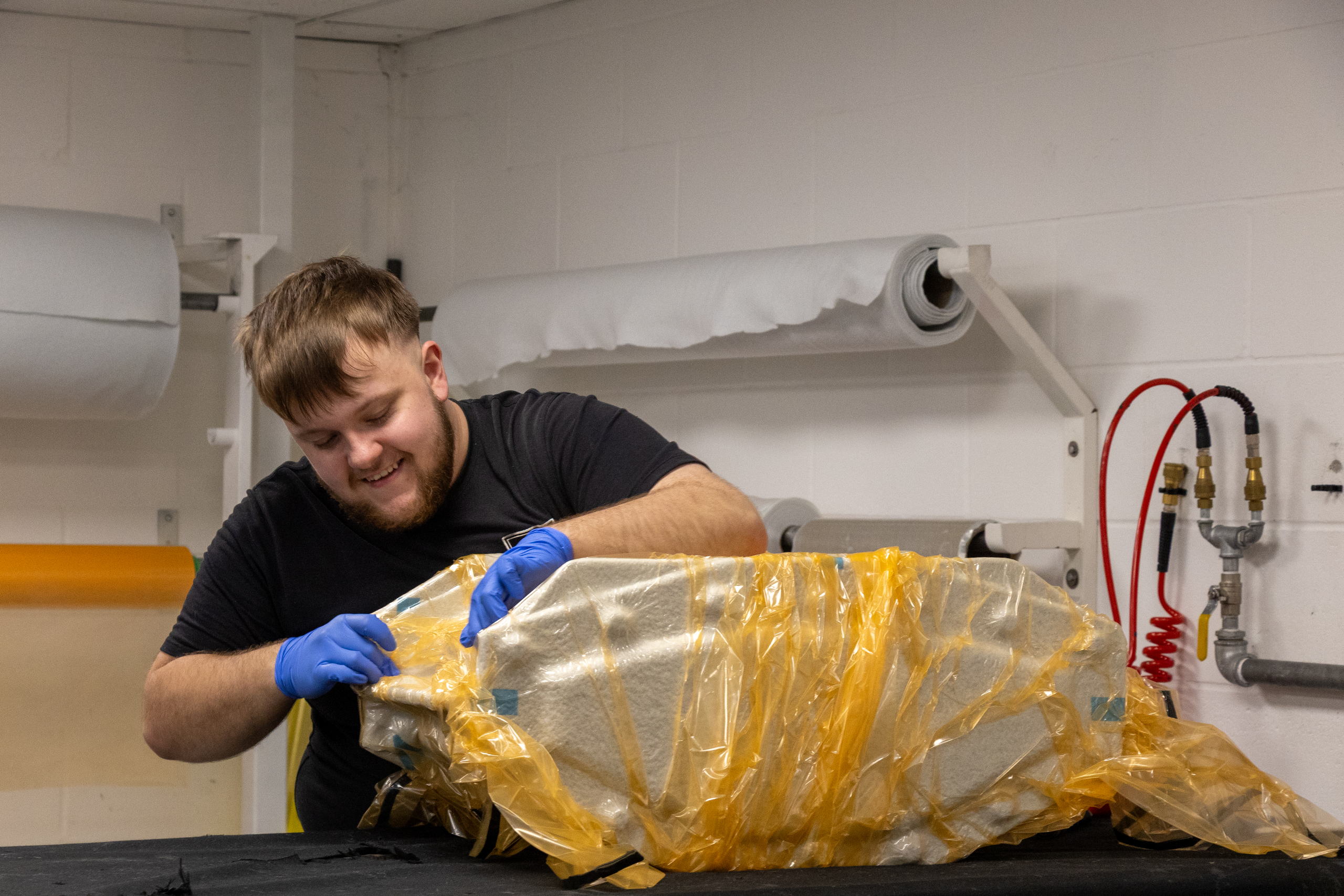 CF Composites technician vacuum bagging a composite part
