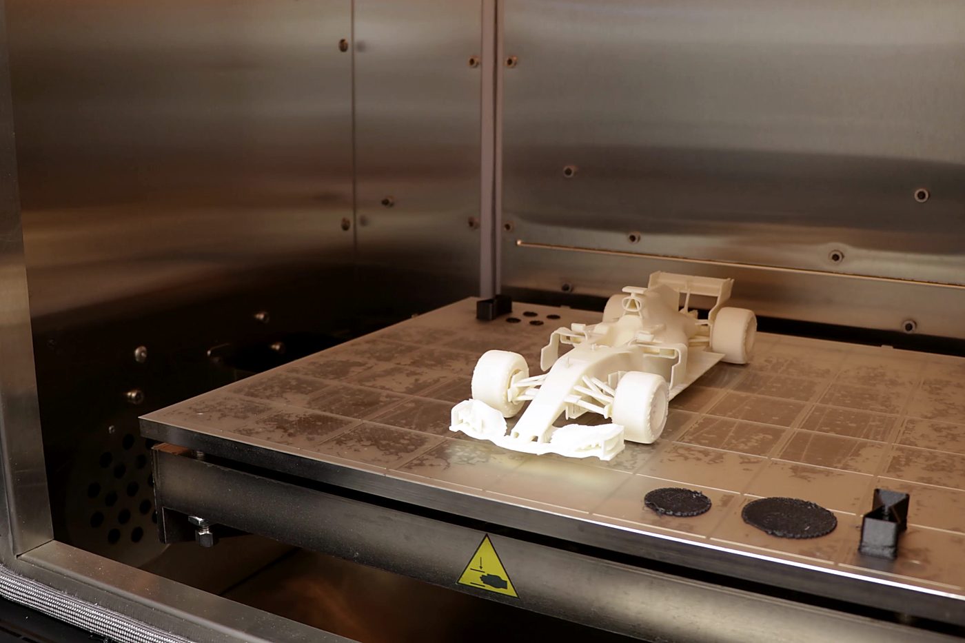 Printed polymer chassis model on the build plate of a 3D printer