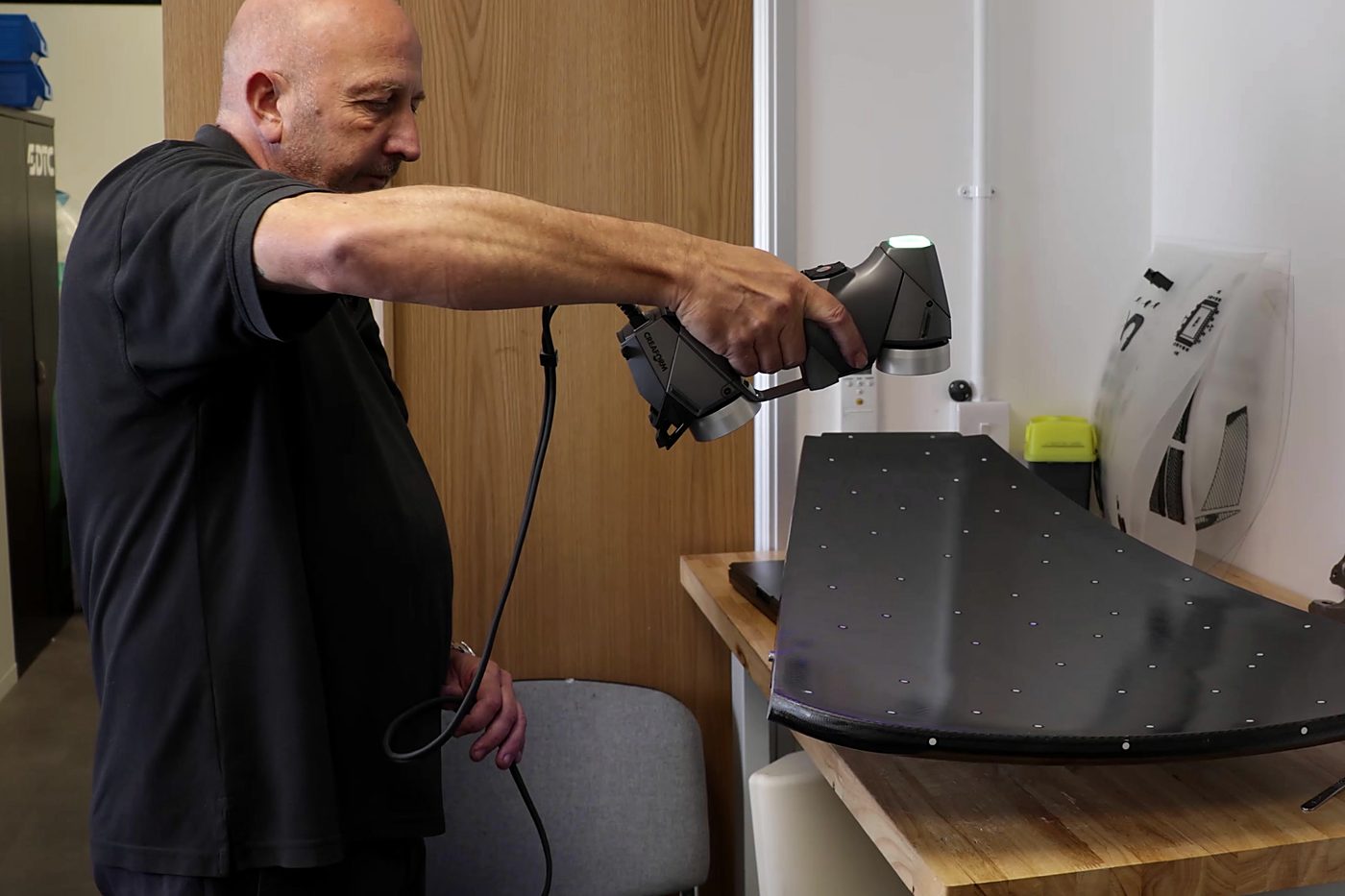 Technician scanning a composite panel with a handheld 3D scanner